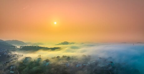 Fototapeta na wymiar Aerial view of Xuan Tho suburbs near Da Lat city at morning with misty and sunrise sky. This place is considered most beautiful and peaceful place to watch sunrise in highlands of Vietnam