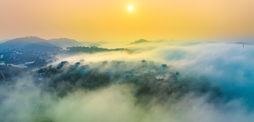 Aerial view of Xuan Tho suburbs near Da Lat city at morning with misty and sunrise sky. This place is considered most beautiful and peaceful place to watch sunrise in highlands of Vietnam