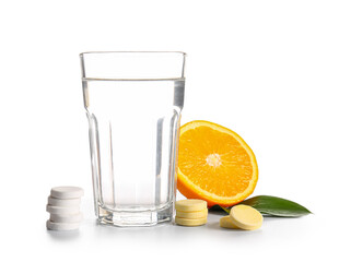 Glass of water, vitamin C effervescent tablets and orange isolated on white background