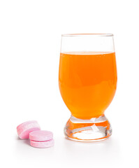 Glass of effervescent tablet dissolved in water and pills isolated on white background