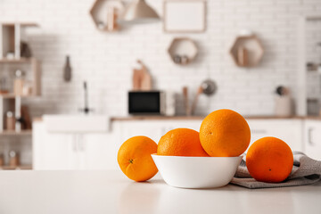Bowl with oranges on table in interior of modern kitchen