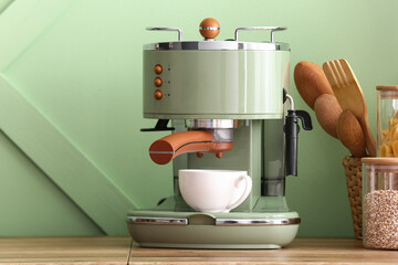 Modern coffee machine with cup on kitchen counter