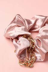 Silk scrunchy and bracelet on pink background, closeup