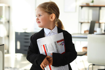 Funny little businesswoman with newspaper in office