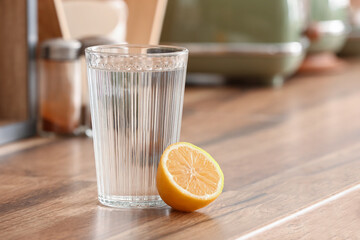 Glass of water and lemon on kitchen counter