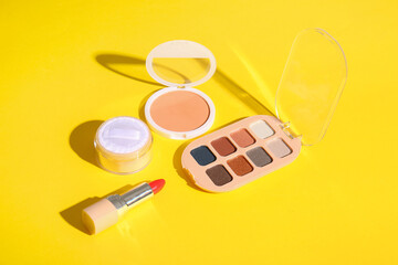 Set of decorative cosmetics on yellow background