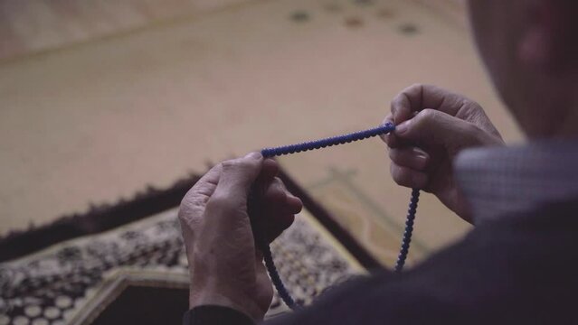 Man praying with misbaha or rosary