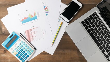 On the work desk, there are several business accessories and charts.