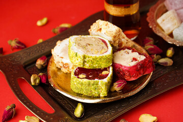 Tray with tasty Turkish delight on red background, closeup