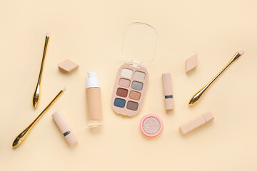Decorative cosmetics with sponges and brushes on yellow background