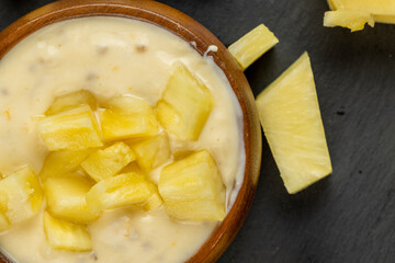 milk pineapple yogurt with pieces of pineapple and other fruits