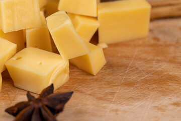 Yellow hard cheese sliced on a board