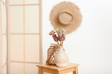 Fototapeta na wymiar Vases with decorative pineapples on table in light room