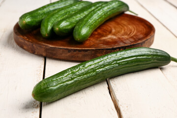 Fresh cucumber on light wooden background, closeup