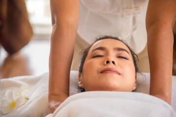 Fototapeta na wymiar Professional masseuse doing shoulder massage beautiful asian woman with close up shot in spa room.