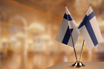 Small flags of the Finland on an abstract blurry background