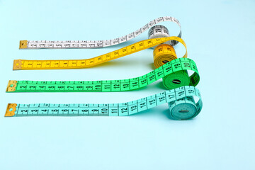 Colorful measuring tapes on blue background