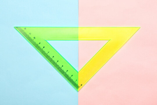 Green and yellow plastic ruler on color background