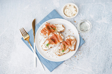 Plate of tasty bruschettas with jamon on light background