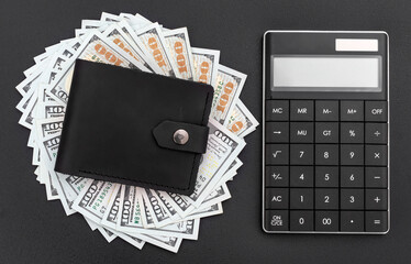 Wallet with dollar bills and calculator on black background. Top view. Calculating money and salary.