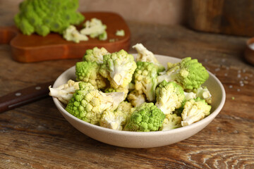 Bowl with baby romanesco cabbage on wooden table