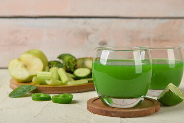 Glasses of tasty green juice on grunge table