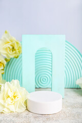 Decorative plaster podiums with flowers on grunge table against white background