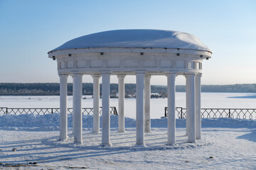 Round gazebo-rotunda on the city embankment against the background of the frozen Volga river, on a frosty January day. Myshkin. Yaroslavl Oblast, Russia