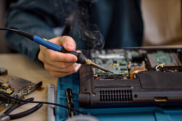 Obraz premium focus on unrecognizable engineer technician hands repairing faulty on laptop computer in electric device technology service, male using special tools. Maintenance notebook support service engineer