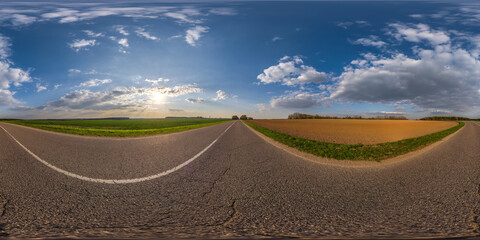 spherical 360 hdri panorama on old asphalt road with cracks with clouds and sun on evening blue sky...