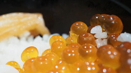 Close up of sashimi salmon roe with rice bowl or donburi in Japanese style food. Fresh raw red Salmon roe or Japanese red caviar. salmon roe pickled in soy sauce on rice. Japanese fierce salmon dishes