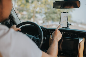 A man drives a car using a GPS navigation system on his mobile phone while driving, to find his...