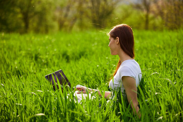 Woman with laptop working in park 