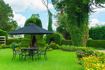 Table, chairs and umbrella set in the garden, in the relax area © VitaL