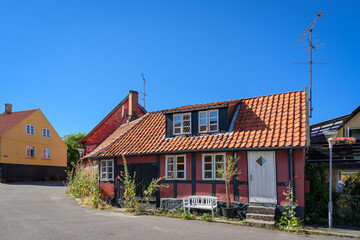 Fototapeta na wymiar Eingeschossiges altes Fachwerkhaus mit weißer Sitzbank in Allinge auf Bornholm
