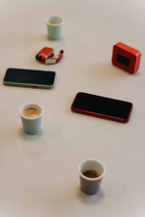 Obraz na płótnie Canvas Cups of coffee, phones, speaker and car keys on the table
