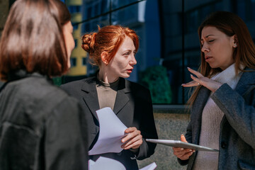 Blonde businesswoman explaining a solution for their project problem. She is gesticulating with her...