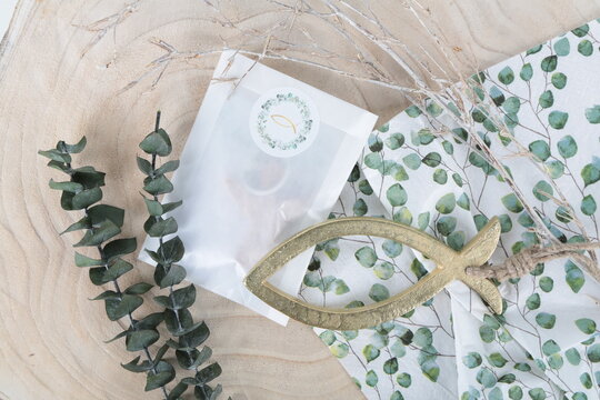 Gedeckter Tisch mit Fisch Symbol in Naturfarben mit Eukalyptus in weiß, grün, braun, natürliche Tischdekoration zum Fest