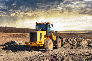 Powerful front wheel loader or bulldozer working on a quarry or construction site. earthworks in construction. Powerful modern equipment for earthworks.