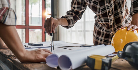 engineer people meeting working and pointing at a drawings in office for discussing. Engineering tools and construction concept.