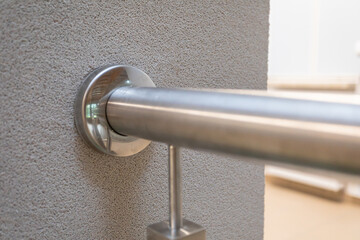 Attached round stainless steel railing bracket to the wall.