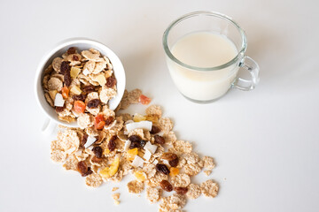 Whole grain cereal flakes with dried fruit and milk. Wholegrain breakfast cereals isolated on a white background
