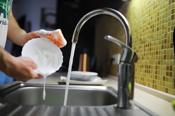Man washing dish in sink at restaurant.People are washing the dishes too Cleaning solution