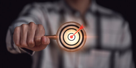 Businessman holding magnifying glass and arrow icon hits center of dart board target ,Setting...