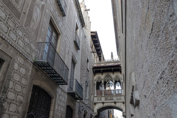 Fototapeta na wymiar View of the Pont del Bisbe, a striking Gothic-style bridge built in 1928, located at Carrer del Bisbe in the Gothic Quarter, the historic heart of Barcelona, Spain. 