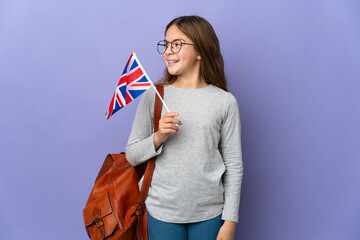 Child holding an United Kingdom flag over isolated background looking to the side and smiling