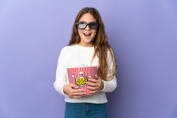 Child over isolated purple background with 3d glasses and holding a big bucket of popcorns
