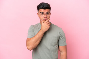 Young caucasian handsome man isolated on pink background thinking