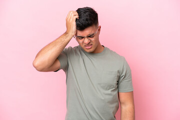 Young caucasian handsome man isolated on pink background with headache