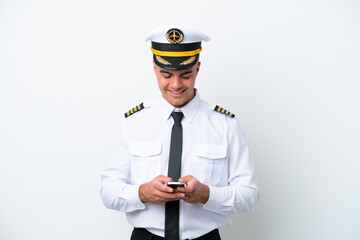 Airplane pilot caucasian man isolated on white background sending a message with the mobile